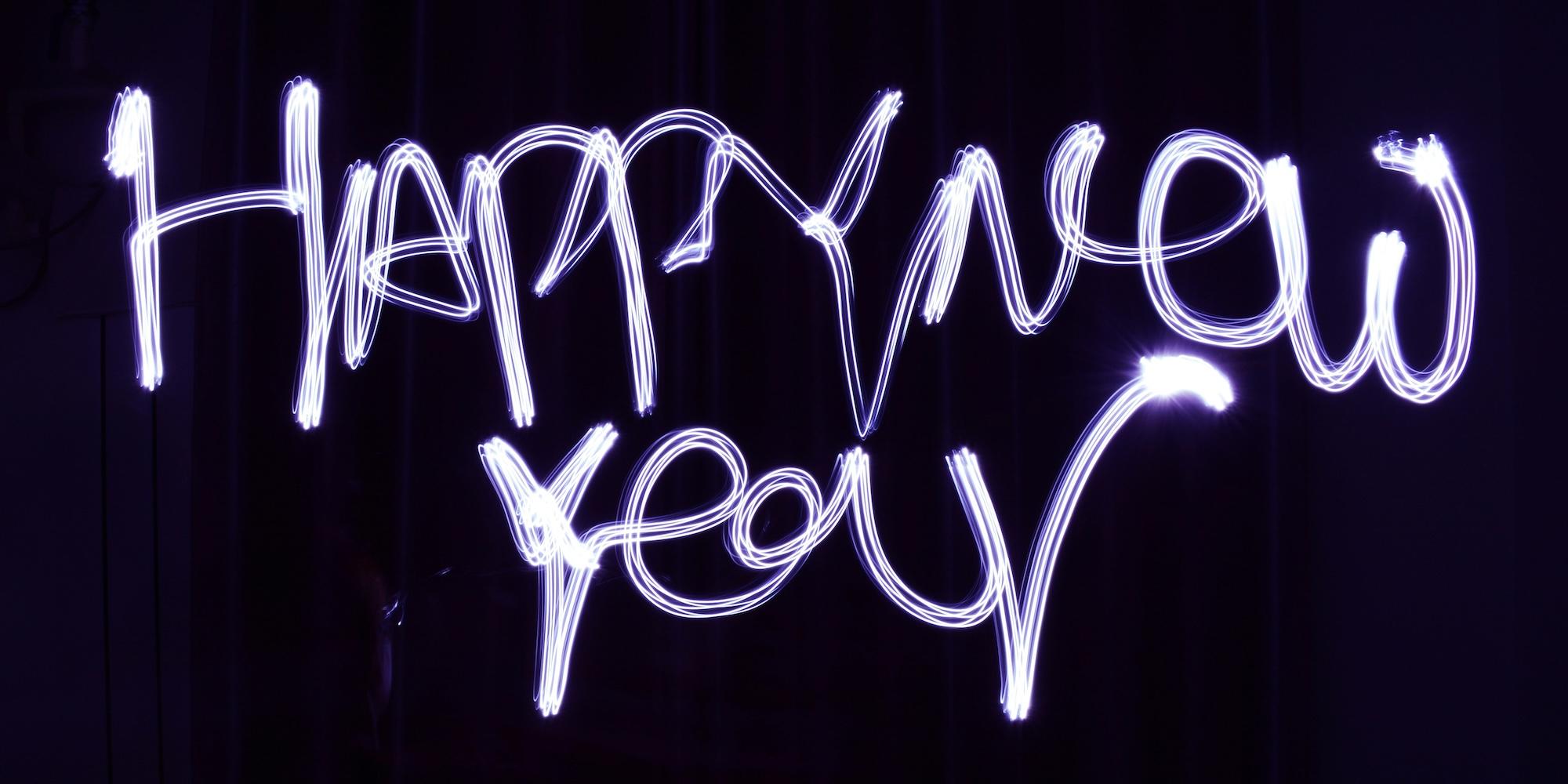 Cover image for this post: A long exposure of the words 'Happy New Year' written in lights.